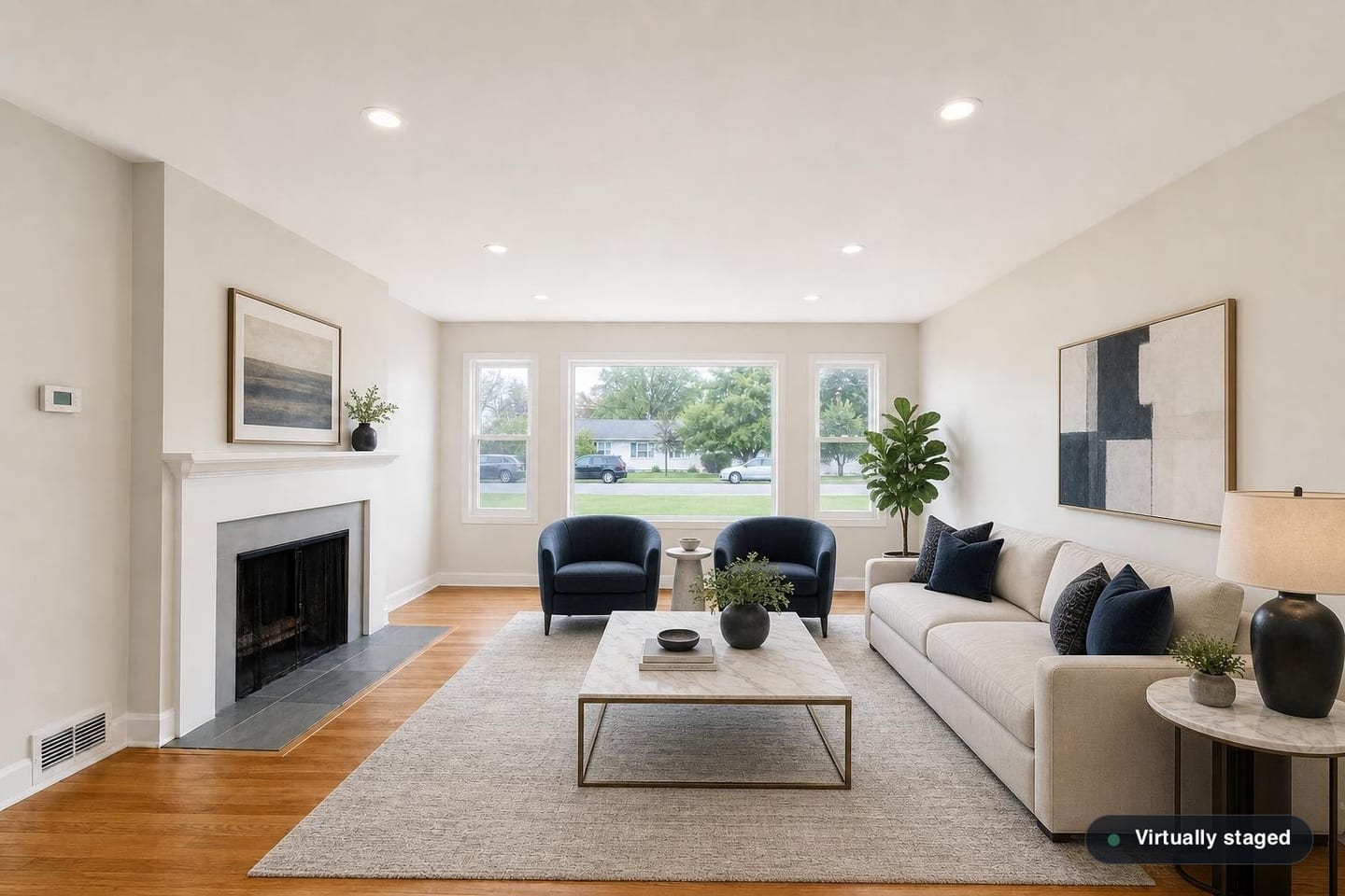 The same empty ranch front living room, shown before and after virtual staging in a Luxury Contemporary scheme with a deep sofa, two navy swivel chairs, a marble-topped coffee table on a brass frame and a large table lamp — after